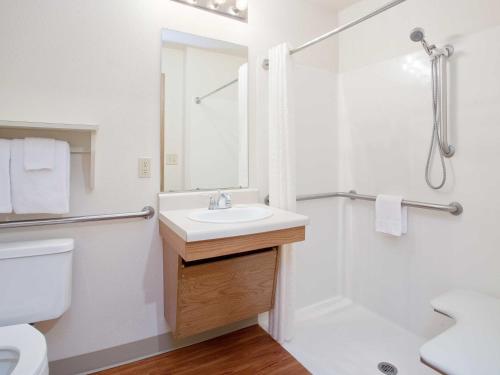 a bathroom with a sink and a shower at WoodSpring Suites Kansas City Mission in Merriam