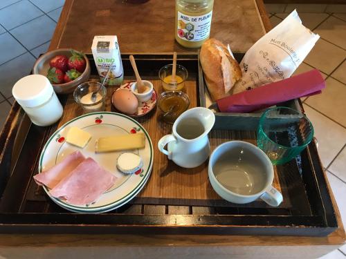 a tray of food with a plate of cheese and bread at Damvix Chambre d hôtes La Barbée in Damvix