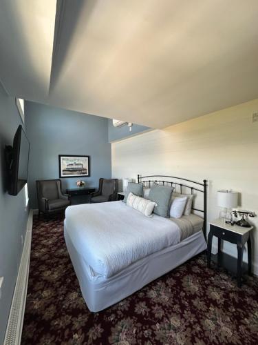 ein Schlafzimmer mit einem großen weißen Bett und einer Couch in der Unterkunft National Hotel in New Shoreham