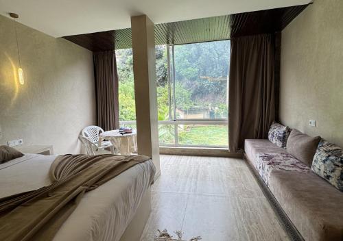 una camera da letto con un divano e una grande finestra di Hotel Asael a Ourika