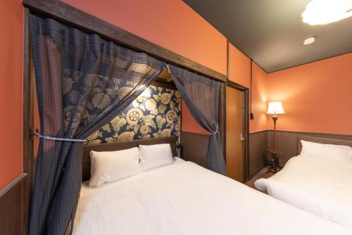 two beds in a room with orange walls at Nagoya JADE GRACE in Nagoya