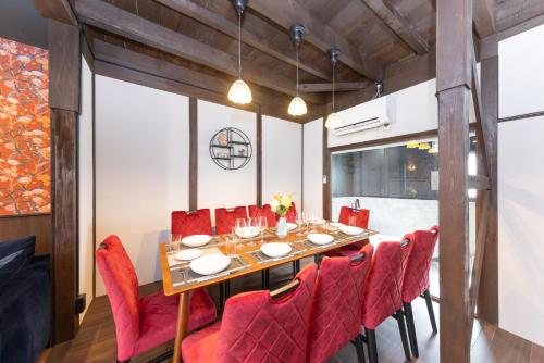 a dining room with a table and red chairs at Nagoya JADE GRACE in Nagoya