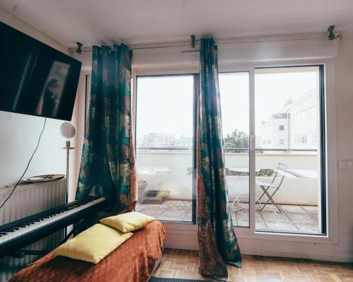 a bedroom with a bed and a large window at Bel appartement balcon - 2 personnes in Malakoff