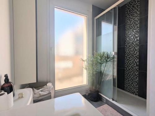 a bathroom with a window and a white sink at Bel appartement balcon - 2 personnes in Malakoff