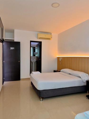 a bedroom with a large bed and a bathroom at Hotel Confort Ariari in Granada