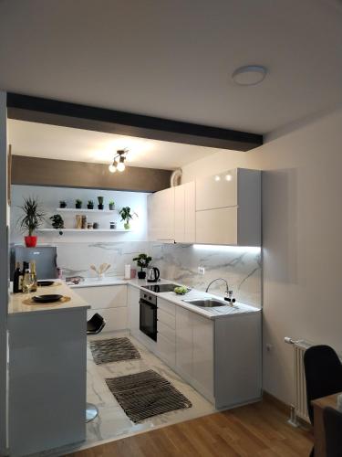 a kitchen with white cabinets and a sink at Allegra lux in Sombor
