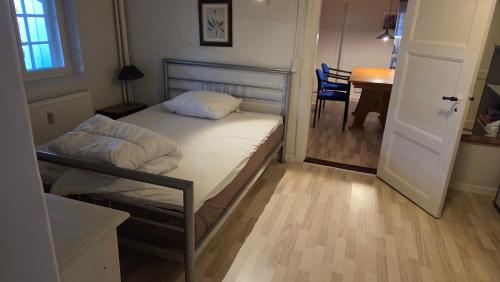 a small bedroom with a bed and a table at Gamle Præstegård, viceværtlejlighed in Årup