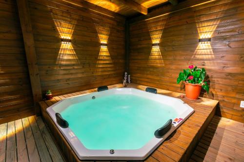 a jacuzzi tub in a wooden room with a plant at Pousada Gauleses - Refugio de Charme na Praia do Rosa by La Vem Férias in Praia do Rosa
