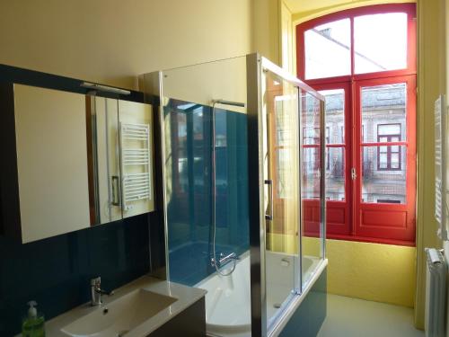 een badkamer met een wastafel, een douche en een raam bij Canvas Atelier Hostel in Porto