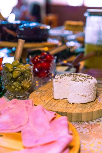 a cake sitting on a wooden cutting board on a table at Pousada Gauleses - Refugio de Charme na Praia do Rosa by La Vem Férias in Praia do Rosa
