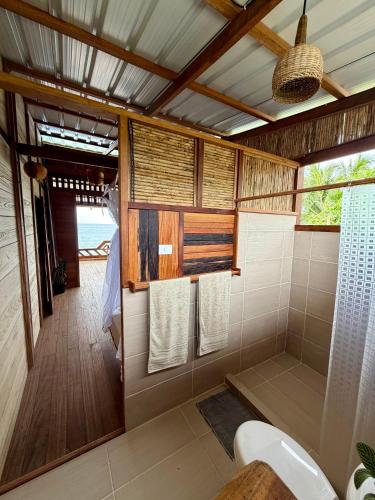 a bathroom with a toilet and a shower with towels at cabaña malambo in Termales - agua caliente - nuqui