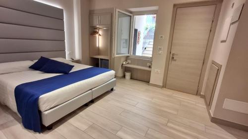 a bedroom with a bed with blue sheets and a window at Hotel Danieli La Castellana lago di Garda in Brenzone sul Garda