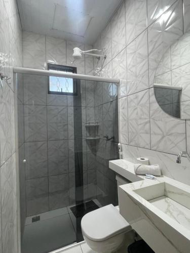 a bathroom with a shower and a toilet and a sink at POUSADA ORTEGA in Bodoquena