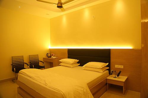 a bedroom with a bed and a table and chairs at Elite Residency Bhadrachalam in Bhadrāchalam
