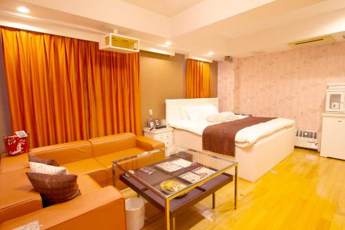 a hotel room with a bed and a living room at Canon Himeji Higashi (Adult Only) in Himeji