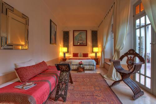 a living room with a couch and a bed at Dar Lalla F'dila in Marrakesh