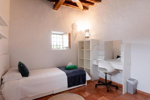 a bedroom with a bed and a desk and a chair at New! Villa Can Marsoch in Santa Eularia des Riu