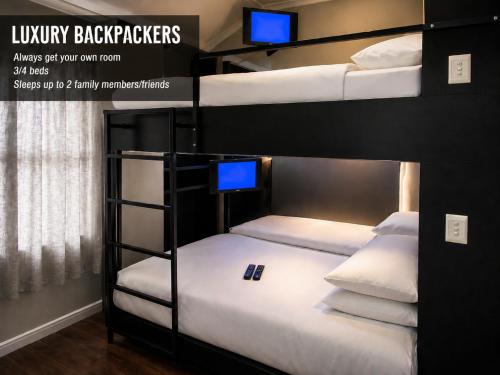 a room with two bunk beds with a tv on top at Luxury Backpackers in Port Elizabeth