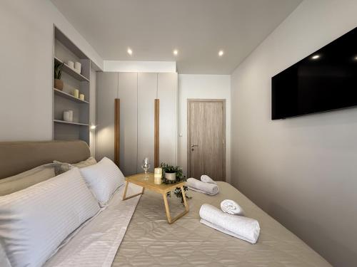 a room with a bed with a table and a television at Blue Tree Suites in Pefkochori