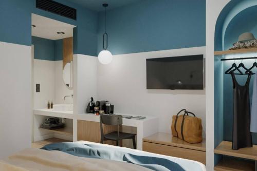 ein Schlafzimmer mit blau-weißen Wänden und einem Schreibtisch in der Unterkunft Play Paros a member of Brown Hotels in Kampos Paros