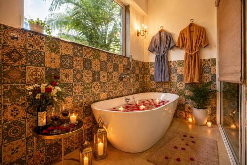 a bathroom with a tub with candles in it at Dimaru Boutique Hotel in Calangute