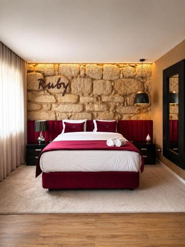 a bedroom with a large bed and a stone wall at Lounge Inn Guest House in Porto