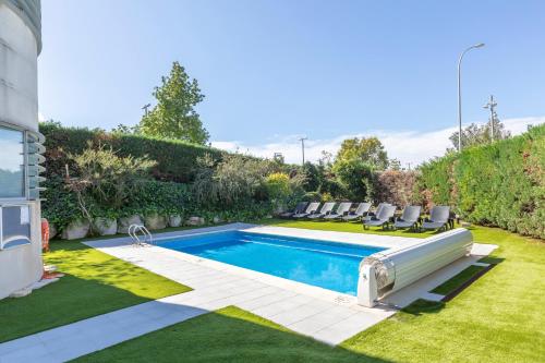 ein Swimmingpool in einem Garten mit Stühlen drumherum in der Unterkunft Acta Sant Just in Sant Just Desvern