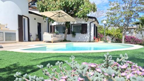 a backyard with a swimming pool and an umbrella at Oasis Villa - Sea View Pool, Sanremo in Sanremo