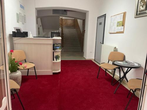 a hallway with chairs and a red carpet at Hotel Eurosan in Slănic-Moldova