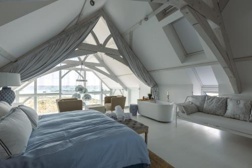 a bedroom with a bed and a couch and a tub at Doleen Quay House in Ballyconneely