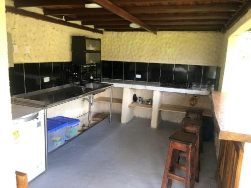 a kitchen with black cabinets and a wooden stool at Finca la Albania in Circasia