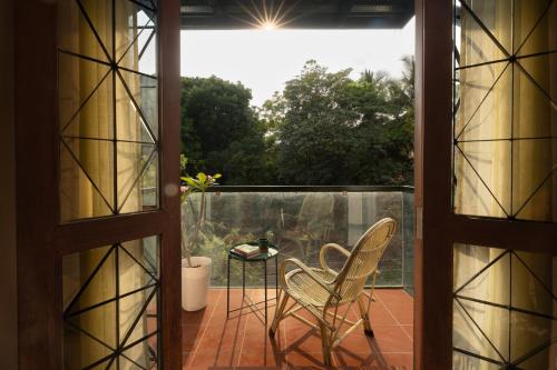 an open door to a balcony with a chair and a table at LiveAway Bengaluru, HSR by PACK in Bangalore