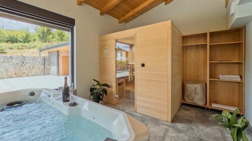a large bath tub in a room with a large window at Villa Tia by Villas Guide in Karlovac