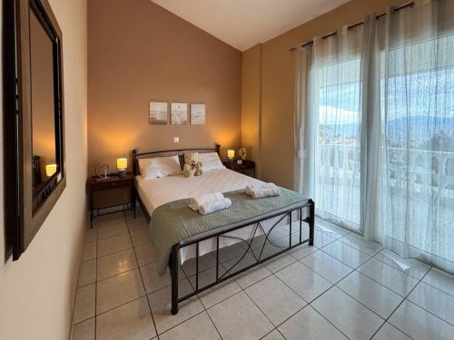 a bedroom with a bed and a large window at Maison De La Mer in Paleo Tsifliki