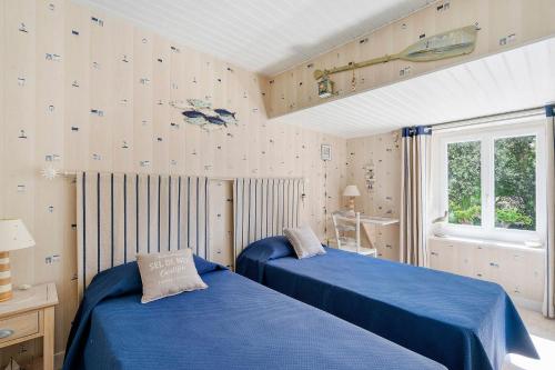 a bedroom with two beds and a window at Chambres Escale Pontilabienne in Pont-lʼAbbé-dʼArnoult