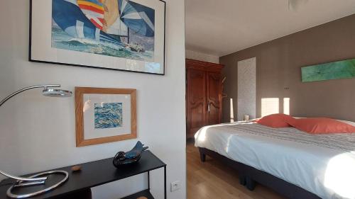 a bedroom with a bed and a desk with a lamp at maison caroline bairon in Le Chesne