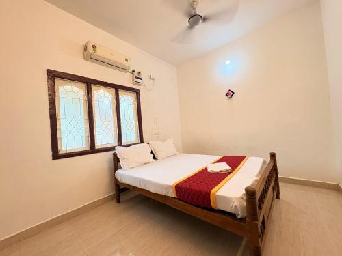 a bedroom with a bed in a room with a window at Neon Villa in Pondicherry