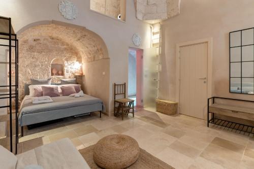a bedroom with a bed and a table in a room at Ostuni Luxury Stay - 2 Jacuzzi in Ostuni