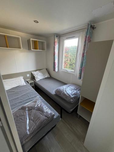 a small room with two beds and a window at Luberon Detente Mobile Home in Cheval-Blanc