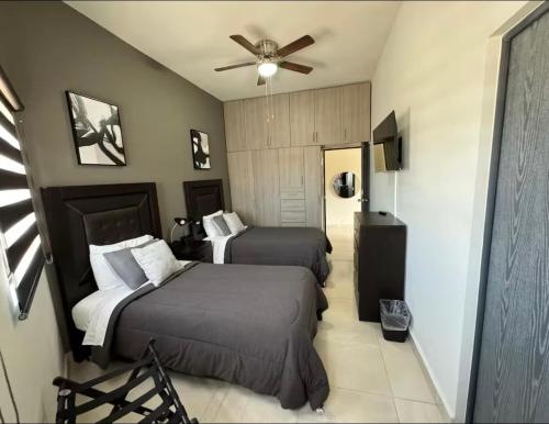 a hotel room with two beds and a ceiling fan at Departamento cerca del Consulado in Ciudad Juárez