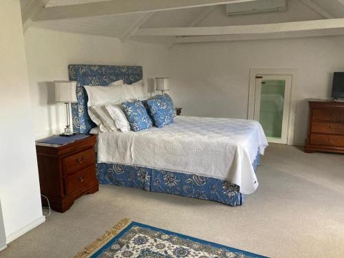 a bedroom with a blue and white bed and a dresser at Maison Fougere in Franschhoek