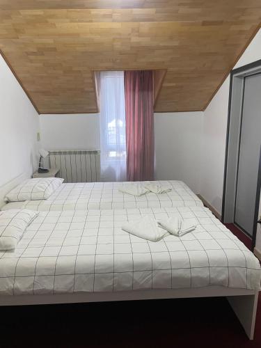 a bedroom with a large white bed with a window at Hotel Eurosan in Slănic-Moldova