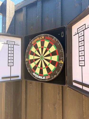 a dart board on a wall with three signs at Casa 135, Sauna, Firepit, BBQ in Ringwood