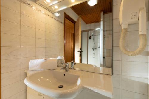 a white bathroom with a sink and a mirror at L'Arveyron Open House in Chamonix
