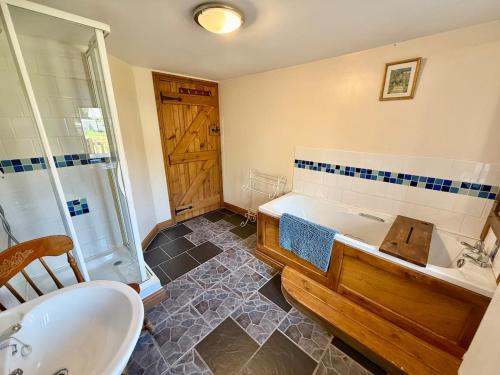 a bathroom with a tub and a sink at Very spacious rural 2 bed barn sleeps 5 in Usk