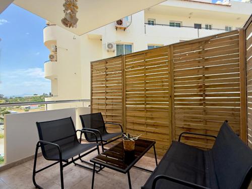 a patio with two chairs and a table on a balcony at Coastal 2BR Apt in Mackenzie Steps from Beach by Cyprus Horizons in Scala