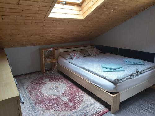 a bed in a room with a wooden ceiling at Chalupa pod smrky in Bedřichov