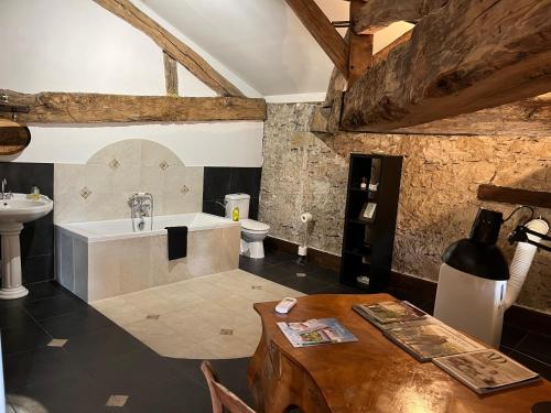 a bathroom with a tub and a sink and a toilet at Moulin de Bapaumes in Nérac
