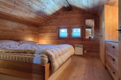 a bedroom with a bed in a wooden cabin at Stadel de Riedmatten in Reckingen - Gluringen