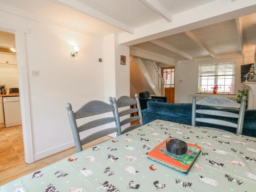 a dining room and kitchen with a table and chairs at September Cottage in Weymouth
